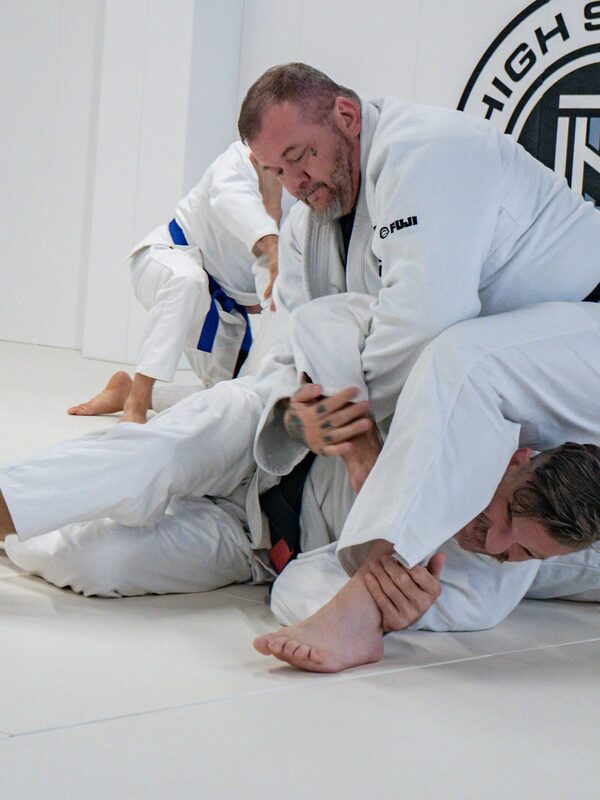 Josh works a guard pass in the gi beneath the High Street seal