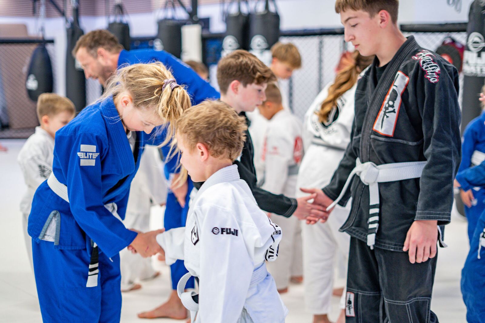 Kids and teens bow and shake hands at the end of class